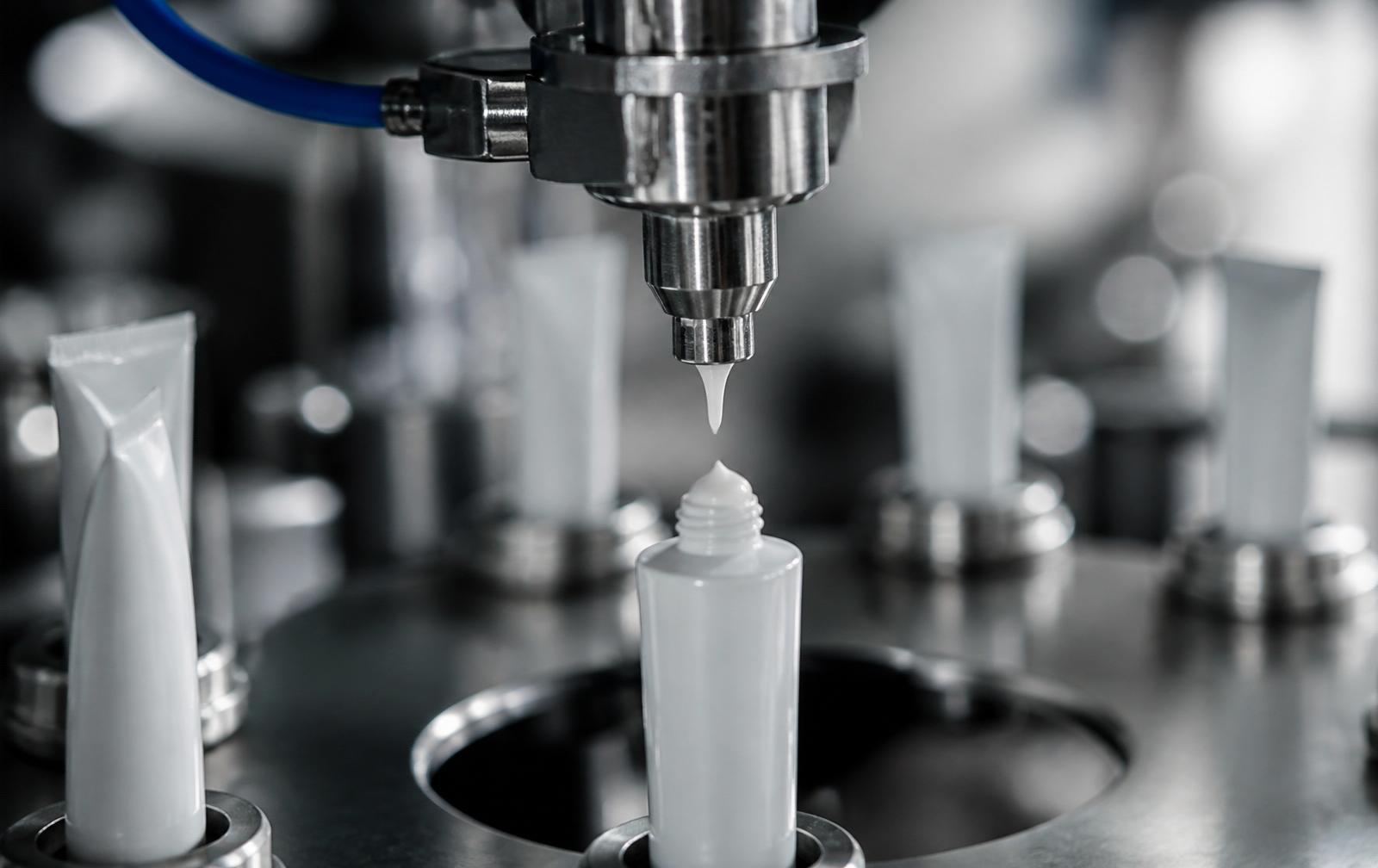 Boquilla automática llenando un envase cosmético